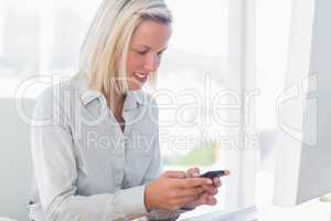 Blonde businesswoman texting