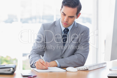 Businessman writing at his desk