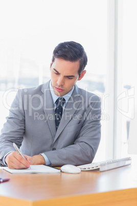 Focused businessman writing at his desk