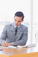 Focused businessman writing at his desk