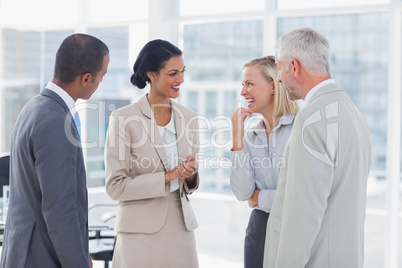 Happy business team chatting and laughing