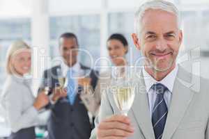 Businessman smiling at camera with champagne