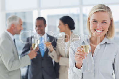 Businesswoman smiling at camera holding champagne