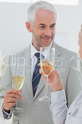 Smiling business partners toasting with champagne