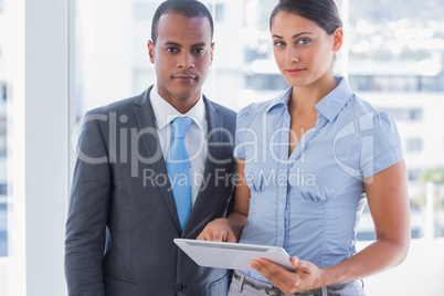 Business team with tablet pc looking at camera