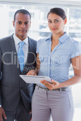 Business team with tablet pc smiling at camera