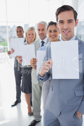 Business team in a line holding white pages