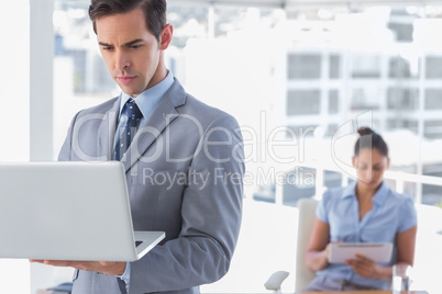 Businessman standing with laptop