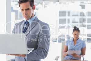 Businessman standing with laptop