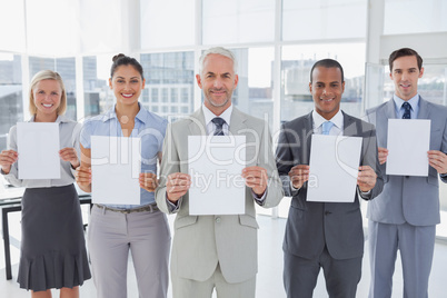 Buisness team holding up blank pages