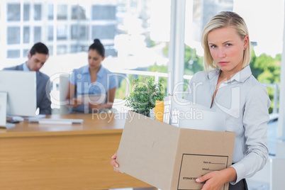 Businesswoman leaving office after being laid off and looking at