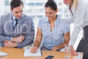 Businesswoman showing colleagues something on notepad