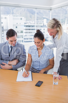 Happy businesswoman showing colleagues something on her notepad