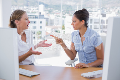 Businesswomen arguing at their desk