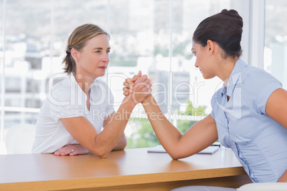 Businesswomen having an arm wrestle