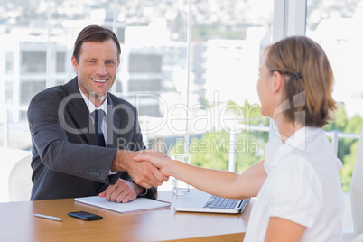 Smiling businessman shaking hand of a job applicant