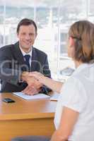 Businessman giving a handshake to a job applicant