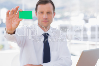 Businessman holding a green business card