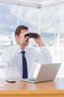 Businessman using binoculars while he is working