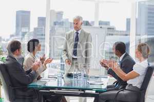 Colleagues applauding the boss during a meeting