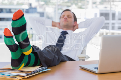 Businessman sleeping with feet on his desk