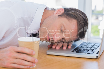 Businessman having a nap on his laptop