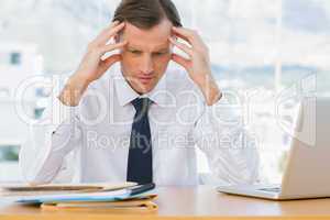 Worried businessman holding his head
