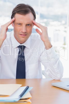 Stressed businessman holding his head