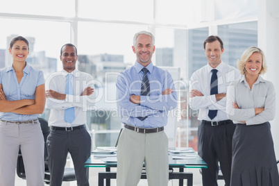 Team of smiling business people standing with arms folded