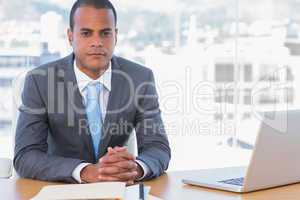 Handsome businessman posing at his desk