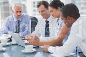 Business people looking at a laptop
