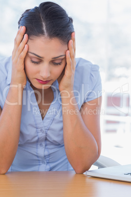 Unhappy businesswoman having her head in hands