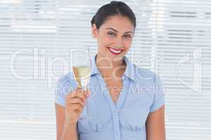 Happy businesswoman holding flute with champagne