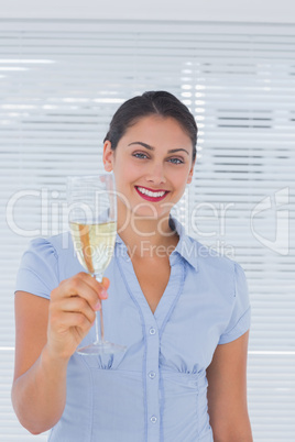 Brunette businesswoman raising a flute of champagne
