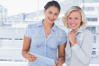 Cheerful businesswomen holding digital tablet