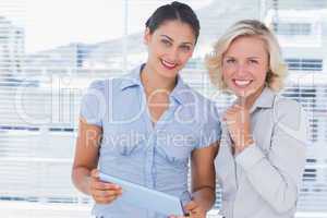 Cheerful businesswomen holding digital tablet
