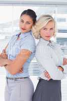 Serious businesswomen with arms folded