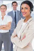 Smiling businesswoman with headset crossing her arms