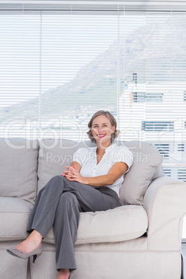 Cheerful businesswoman sitting on couch