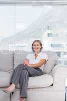 Cheerful businesswoman sitting on couch