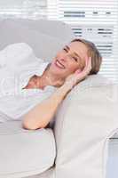 Cheerful businesswoman lying on sofa