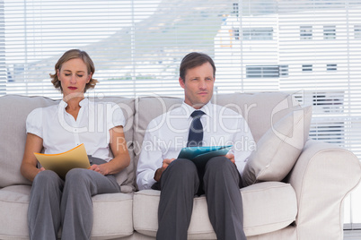 Two business people sitting on couch