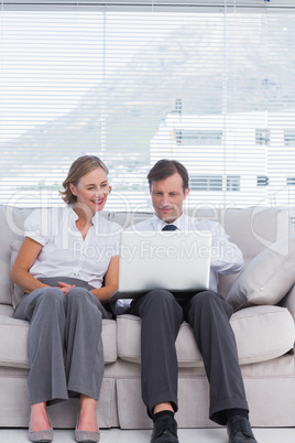 Businessman and woman sitting on couch