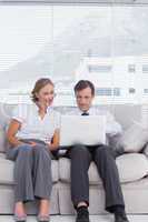 Businessman and woman sitting on couch