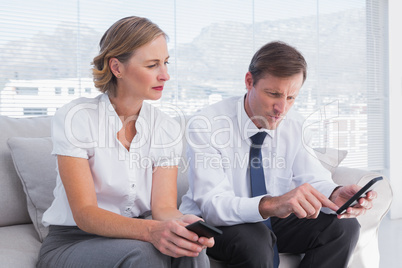 Attractive business partners sitting on couch