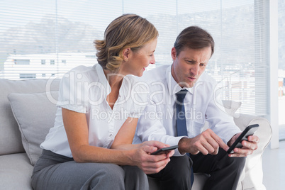 Attractive businessman showing something on his mobile phone to
