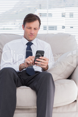 Attractive businessman typing text message