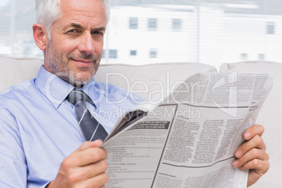 Smiling businessman holding a newspaper