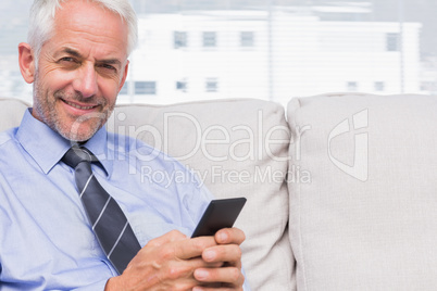 Happy businessman using smartphone