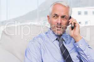 Thoughtful businessman calling on smartphone